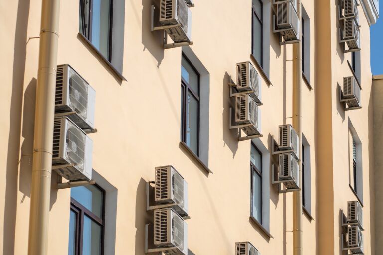 Facade,Of,Building,With,Many,Air,Conditioners,On,Windows,In