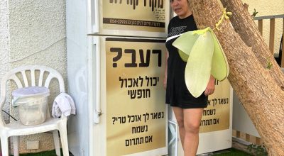 דנית כהן משדרות ליד המקררים הקהילתיים שהציבה בשכונתה. בזכות היוזמה שלה תושבים רבים, שלא יכלו להתפנות מהעיר, הצליחו להשיג מזון טרי בעת שהמרכולים לא פעלו.